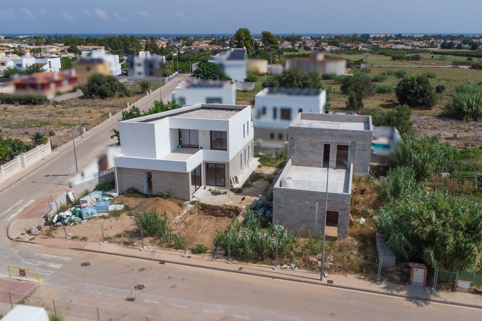 Vue aérienne du projet résidentiel à El Vergel, présentant deux villas modernes en construction avec façades blanches et vues dégagées vers la côte méditerranéenne.