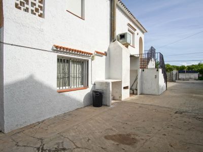 Extérieur de la maison avec barbecue intégré et accès à l'étage supérieur par un escalier.