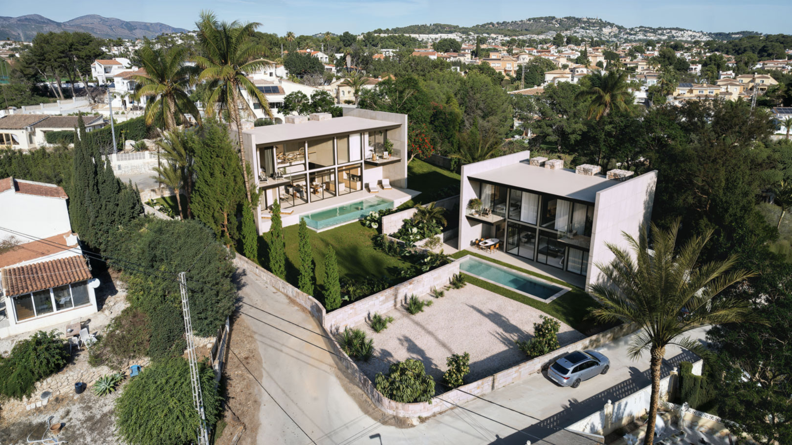 Vue aérienne de deux villas contemporaines avec parois vitrées, piscines rectangulaires et jardins paysagers avec palmiers à Calpe, La Merced.