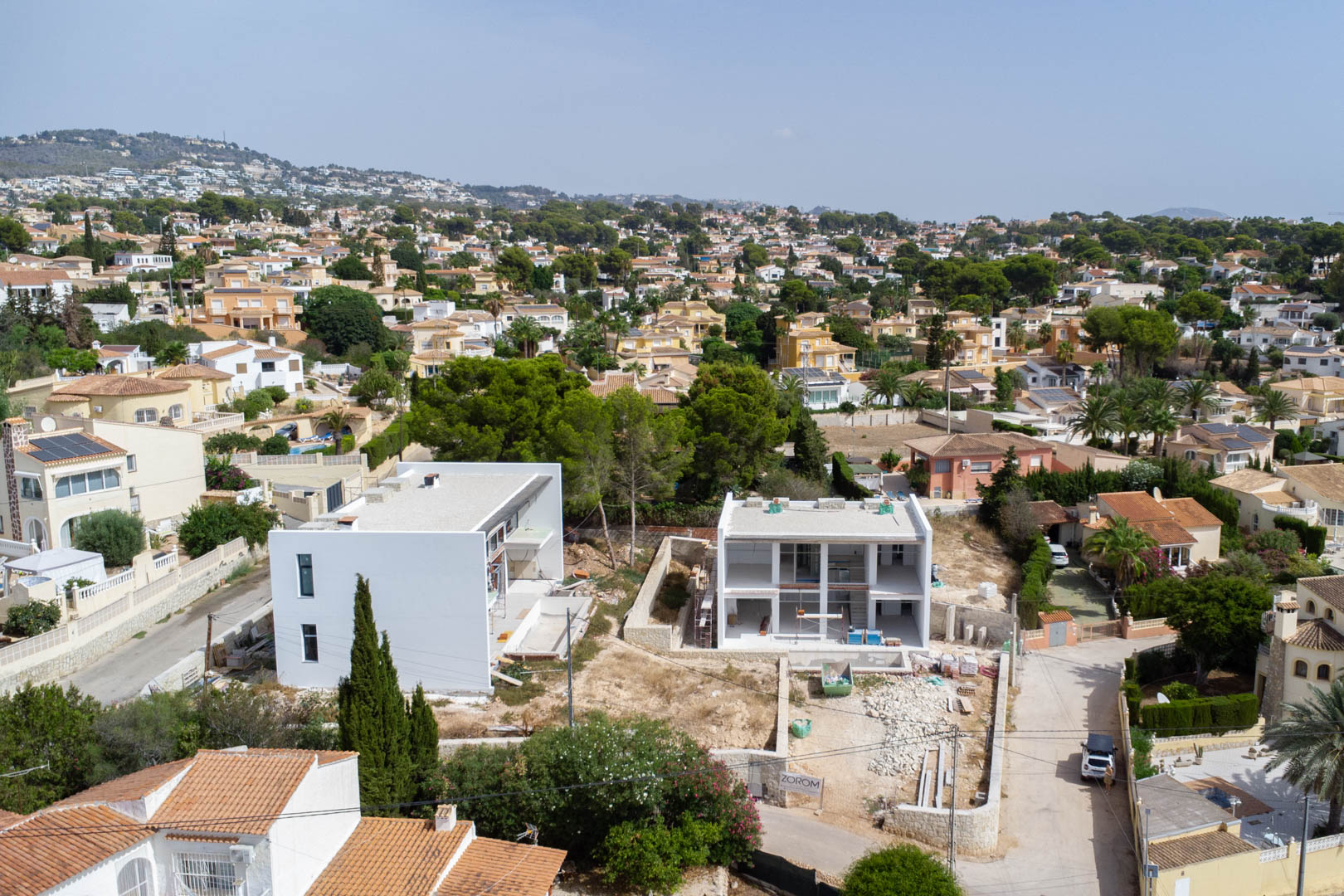 Vue aérienne de la villa en construction à Partida La Merced, Calpe, illustrant la structure moderne à deux niveaux et son intégration dans le quartier résidentiel.