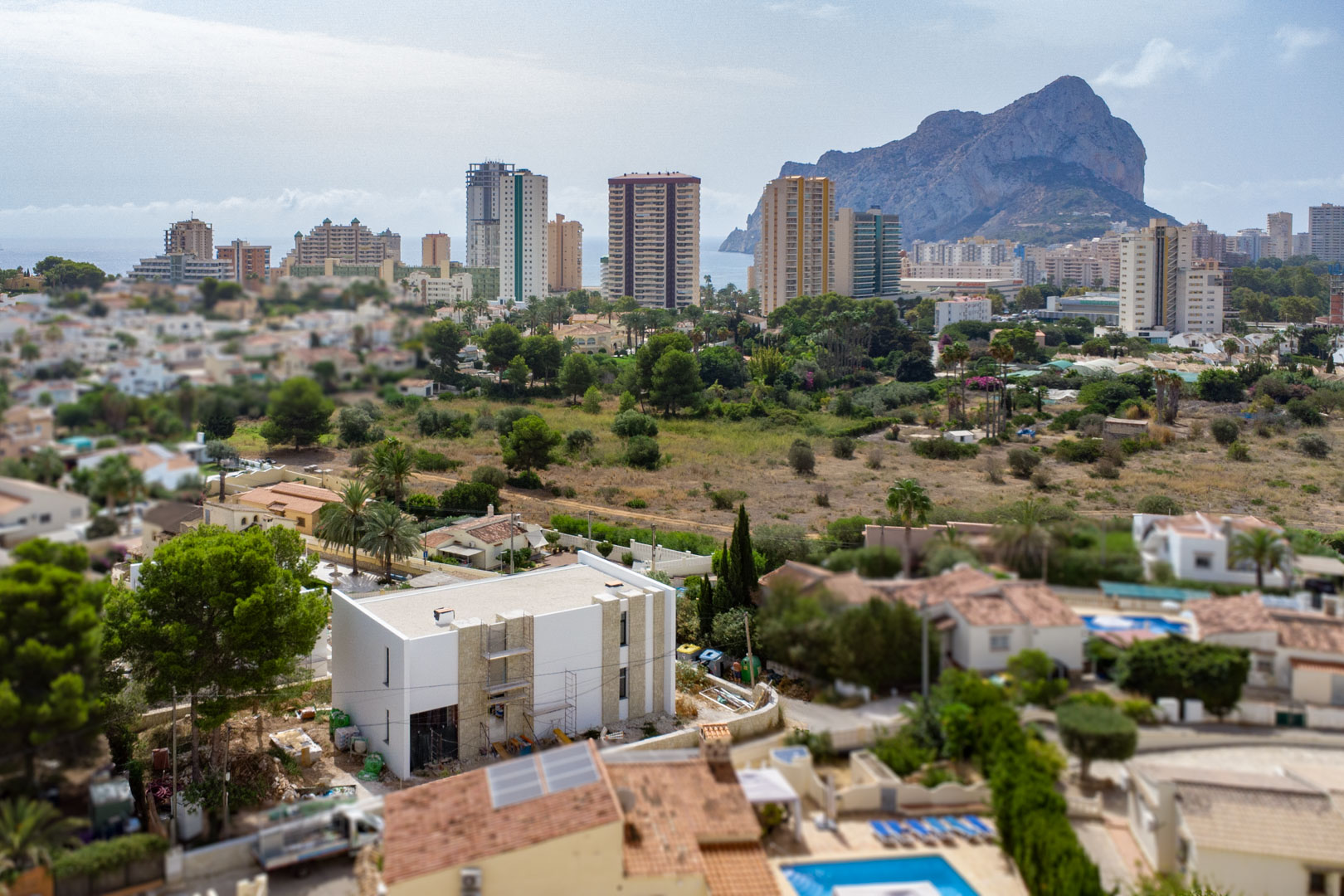 Vue aérienne de la villa en cours de construction, soulignant les détails en pierre de la façade et le panorama sur le Peñón de Ifach et Calpe.