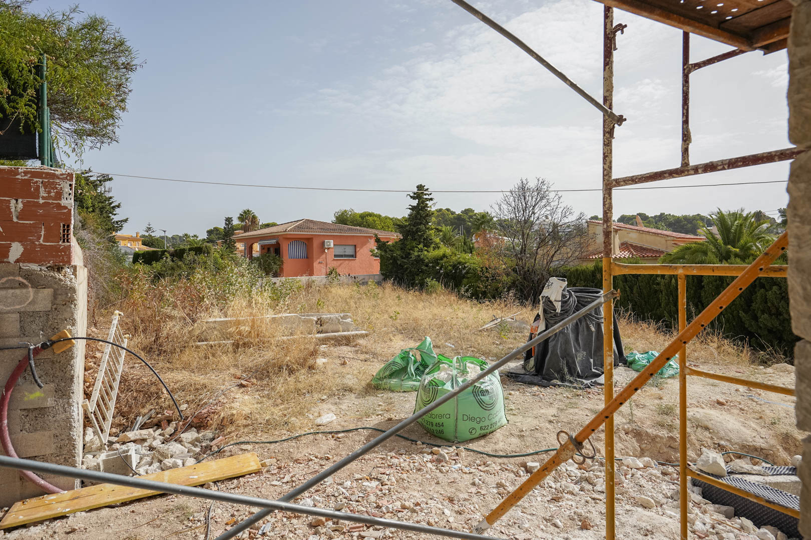 Perspective du terrain plat à Partida La Merced durant la phase initiale de construction, situé dans un quartier résidentiel calme près de la côte de Calpe.