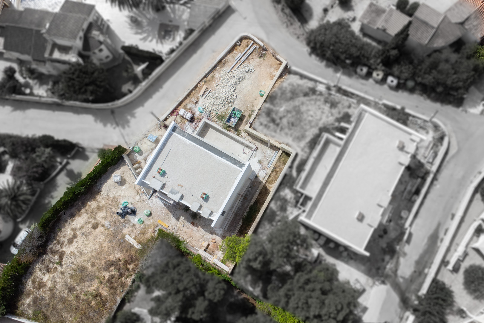 Vue aérienne montrant l'état d'avancement des travaux de la villa sur son terrain plat, située au cœur d'un quartier résidentiel calme à Calpe.