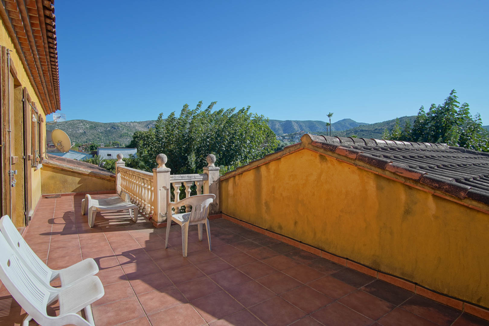 Terrasse à l'étage avec sol en grès rustique et balustrade en pierre, offrant une vue dégagée sur la montagne Segaria et la nature environnante.