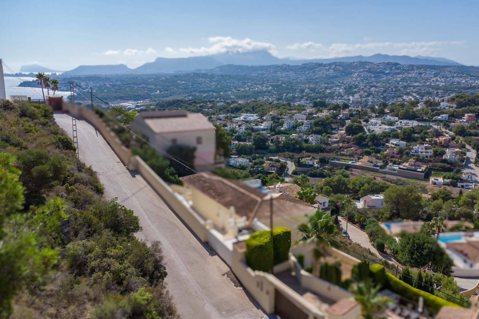 Vue panoramique depuis les hauteurs d'El Portet sur la côte de Moraira, la mer Méditerranée et les montagnes environnantes à l'horizon.