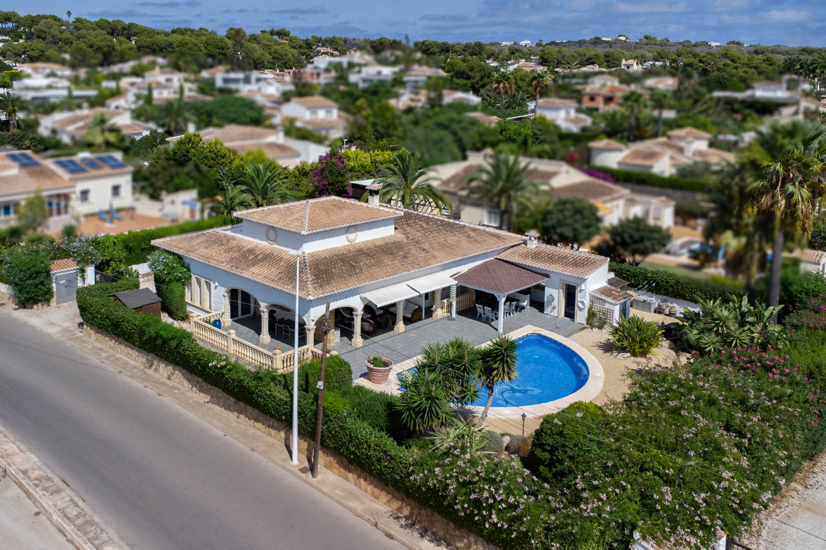 Vue aérienne d'une villa avec piscine privée, terrasse couverte et jardin arboré à Costa Nova, Jávea.