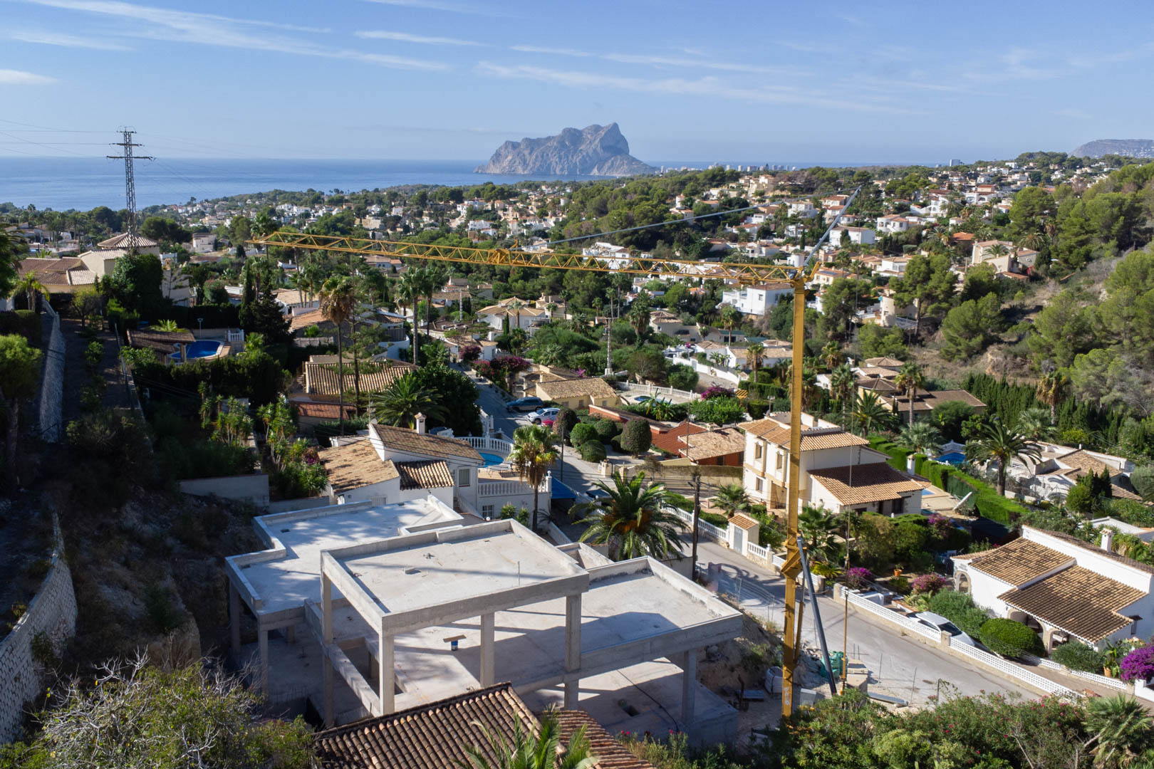Vue surélevée de la structure en béton en cours de construction, offrant un panorama sur la mer Méditerranée et le Peñón de Ifach à Calpe.