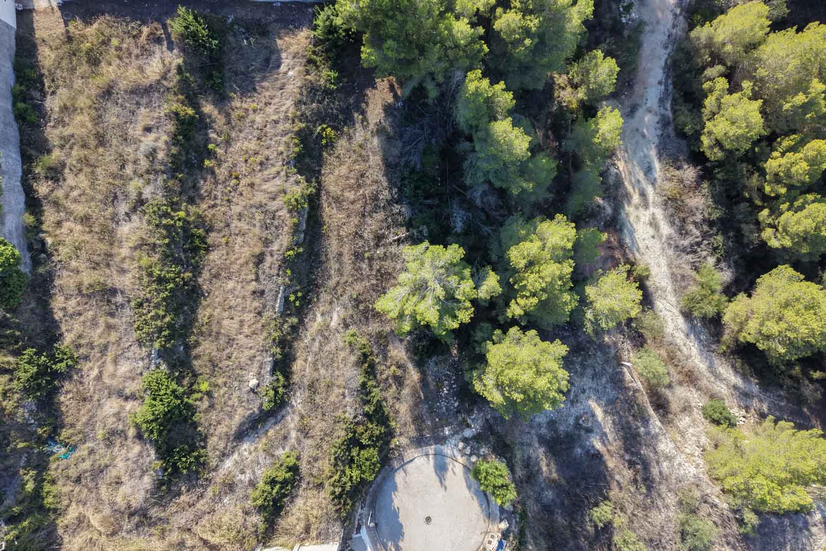 Vue aérienne du terrain urbain montrant sa topographie en terrasses avec des murets en pierre et une végétation méditerranéenne.