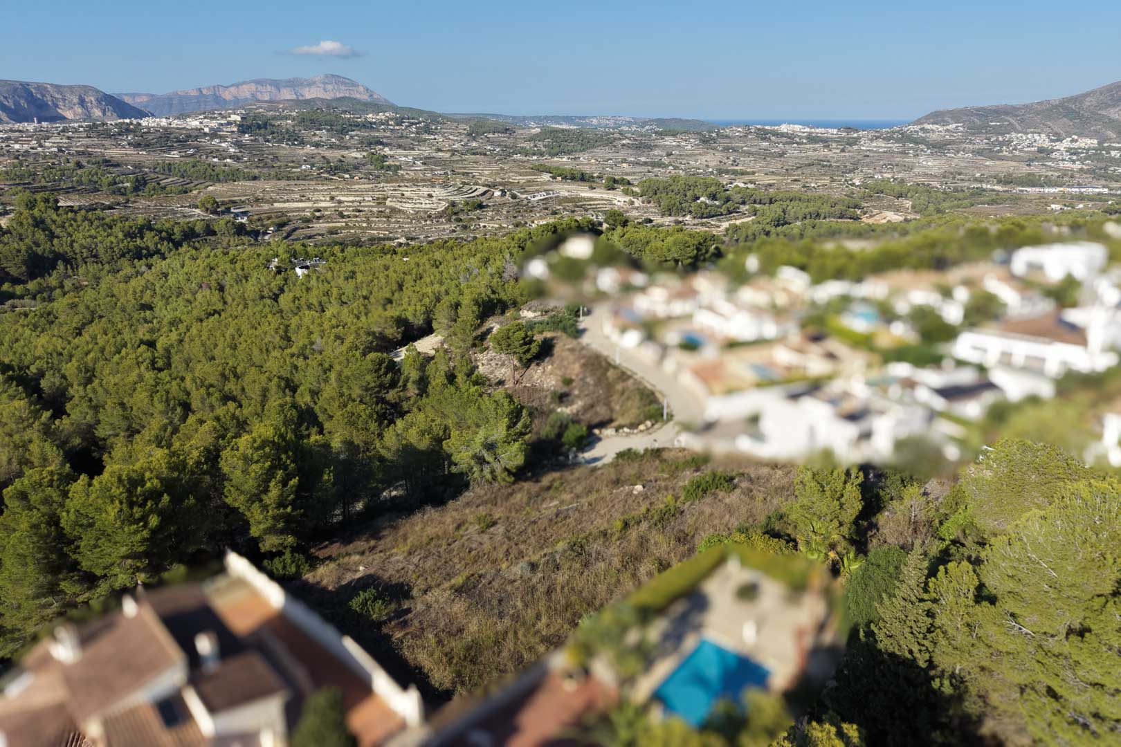 Vue aérienne panoramique révélant la topographie du terrain entouré de pinèdes, avec des vues dégagées sur la vallée et les montagnes environnantes.