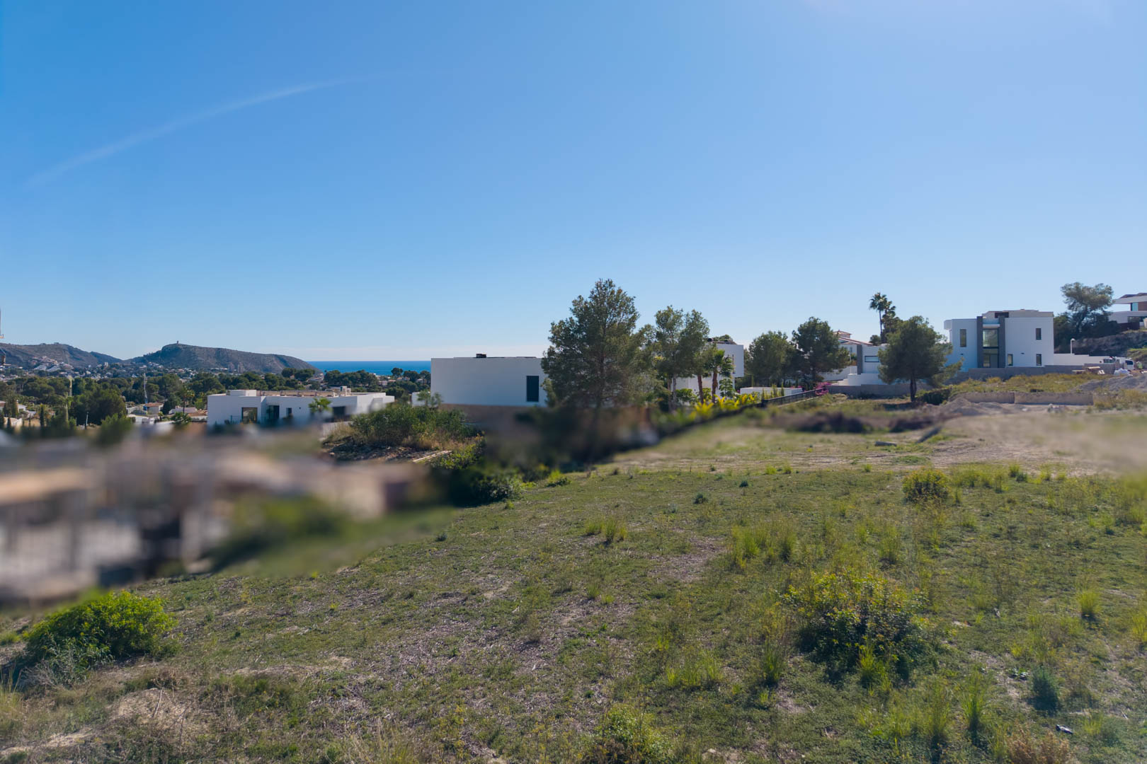 Terrain urbain plat à El Tesoro, Moraira, offrant des vues dégagées sur la vallée et la mer, entouré de villas d'architecture moderne.