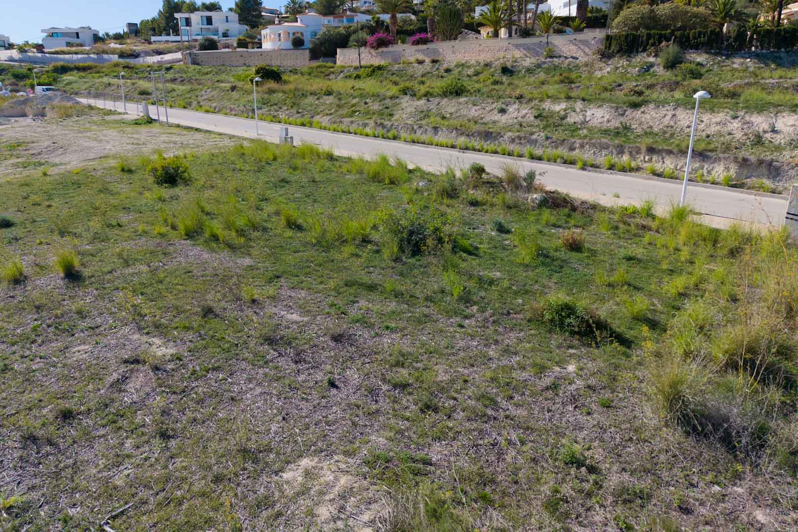 Terrain urbain plat avec accès direct par une rue asphaltée et éclairage public, situé dans le quartier résidentiel en plein essor d'El Tesoro.