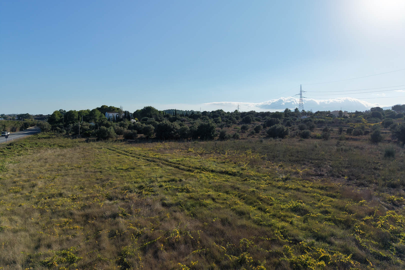 Vue panoramique sur le vaste terrain plat à Teulada, entouré d'une végétation méditerranéenne typique. Un espace extérieur offrant de nombreuses possibilités d'aménagement.