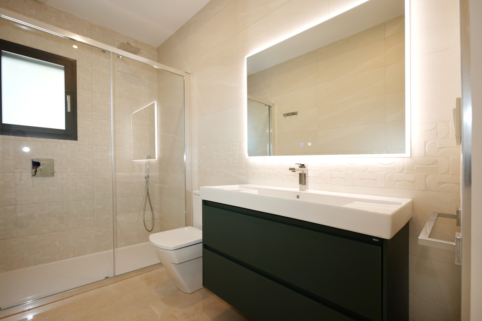 Salle de bain contemporaine avec meuble suspendu anthracite, vasque Roca et miroir LED. Comprend une douche avec paroi en verre et un revêtement mural en grès cérame texturé.