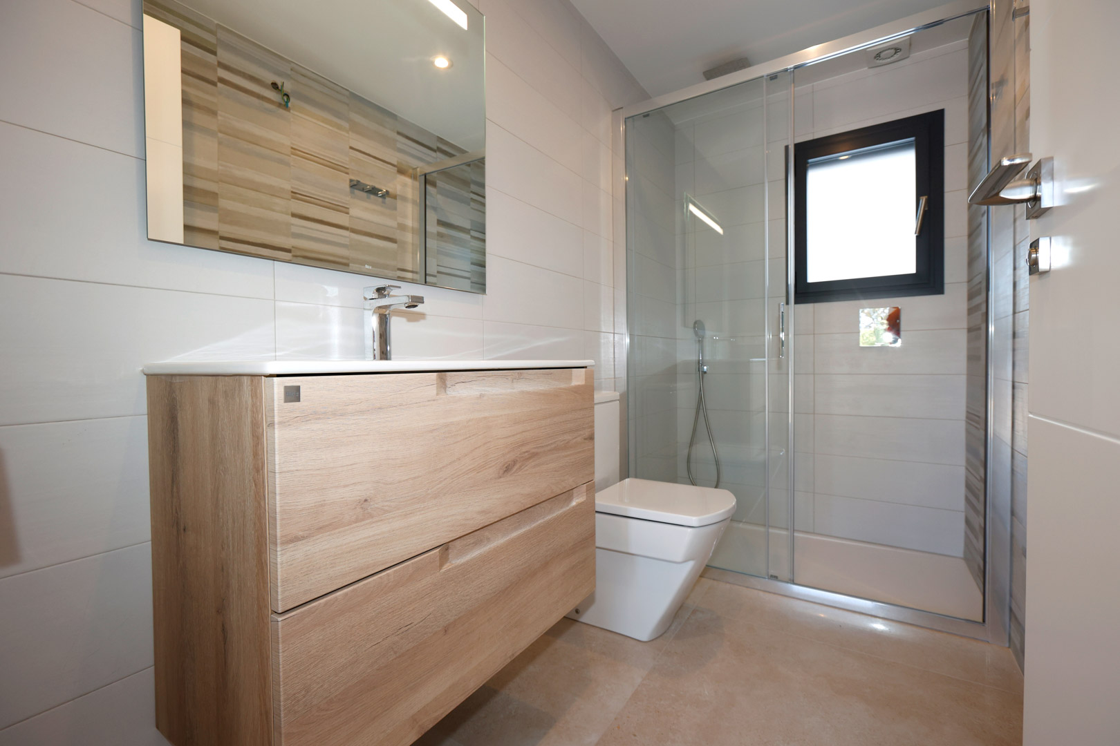 Salle de bain moderne avec meuble en bois, paroi de douche vitrée et carrelage blanc. Finitions élégantes en grès cérame et fenêtre à cadre noir.