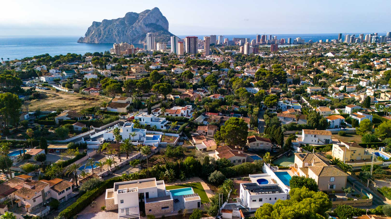 Vue aérienne panoramique de la villa à Calpe, mettant en évidence les panneaux solaires et la vue imprenable sur le Peñón de Ifach et la mer Méditerranée.
