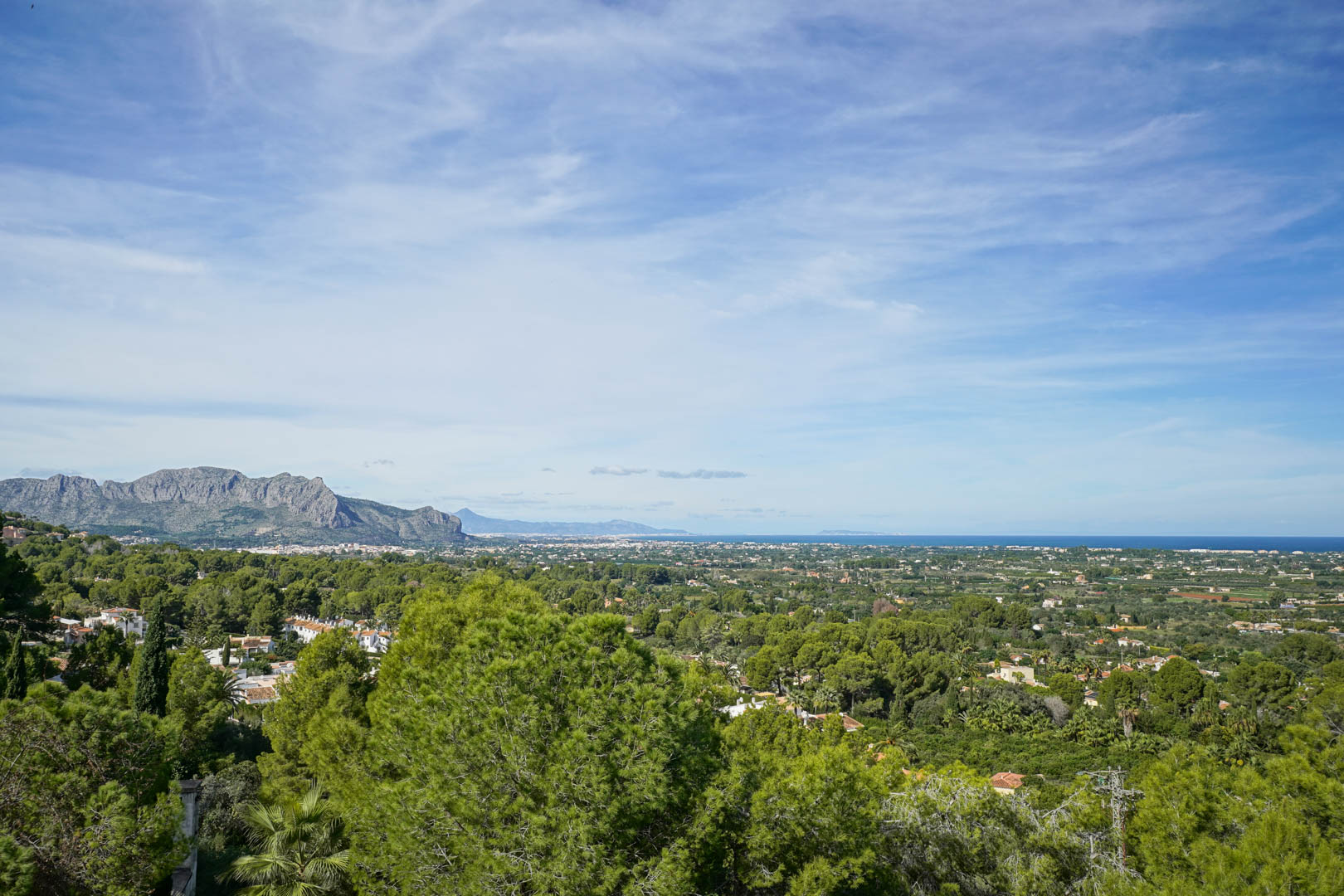 Vues panoramiques depuis La Sella sur le massif du Montgó, la vallée verdoyante et la mer Méditerranée se profilant à l'horizon.