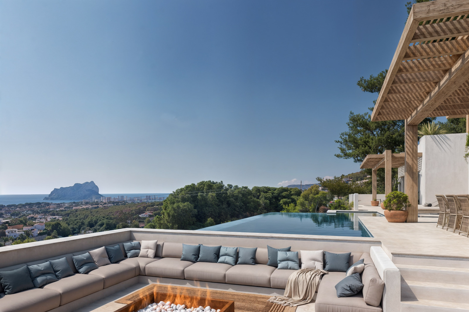 Espace détente encastré avec brasero et piscine à débordement, agrémenté de pergolas en bois offrant une vue panoramique sur la mer.