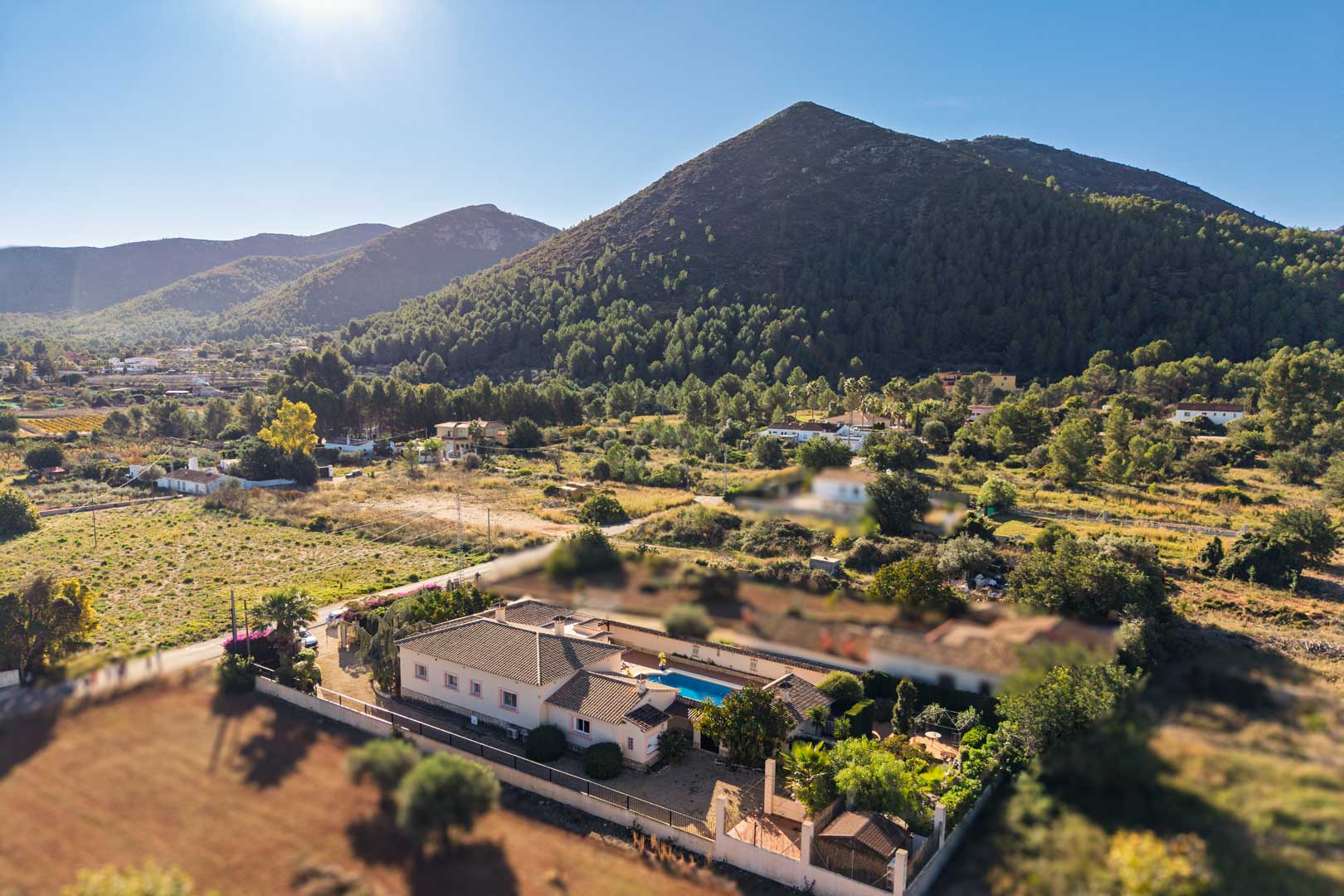 Vue aérienne de la villa méditerranéenne à Jalón, mettant en valeur la piscine privée et le cadre naturel au pied des montagnes.