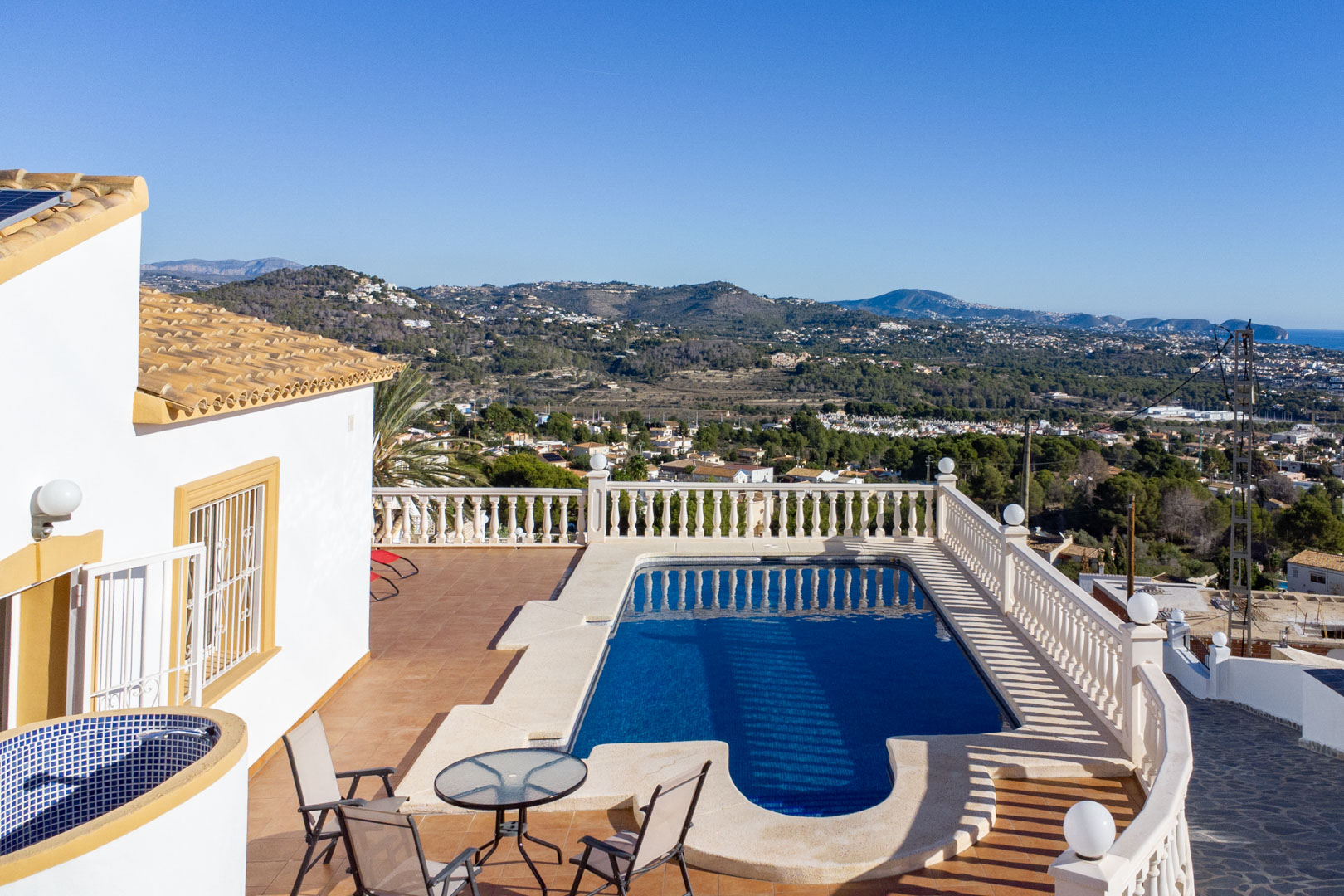Terrasse extérieure avec piscine, balustrades classiques et vue panoramique sur la côte de Calpe et les montagnes environnantes.