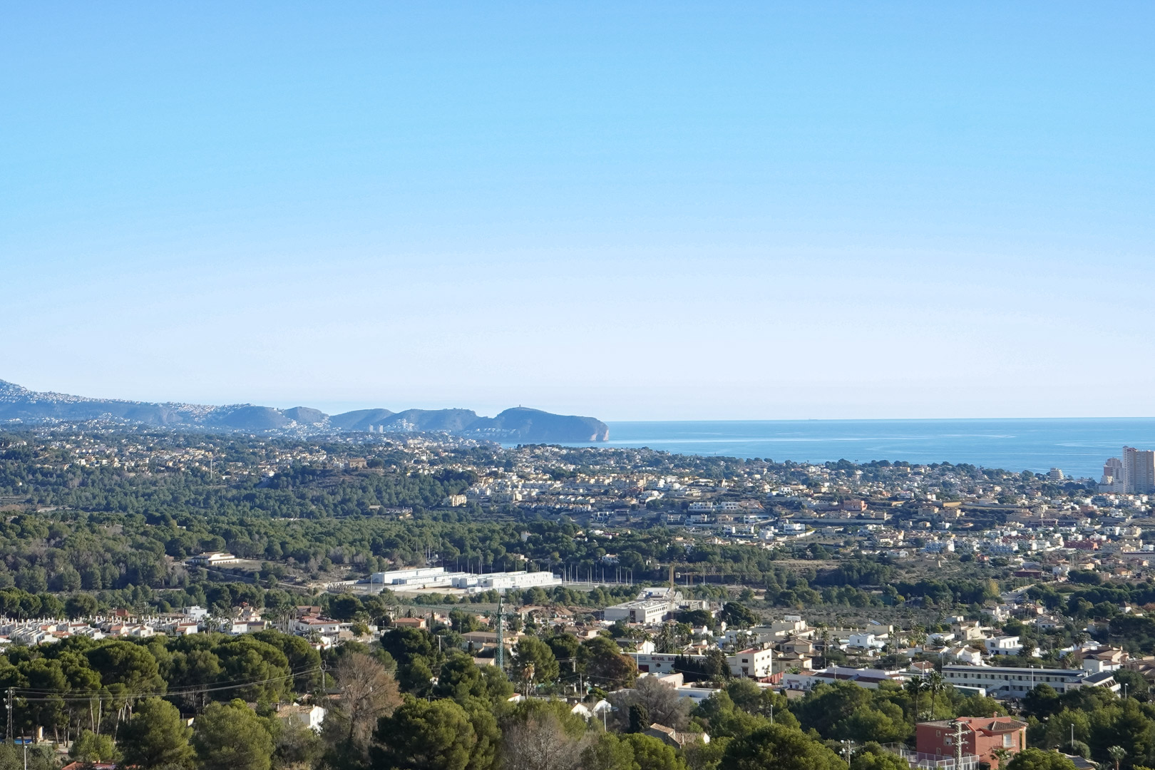 Vue panoramique surélevée sur la côte méditerranéenne et le Cap d’Or, dominant les zones résidentielles et les forêts de pins de Calpe.