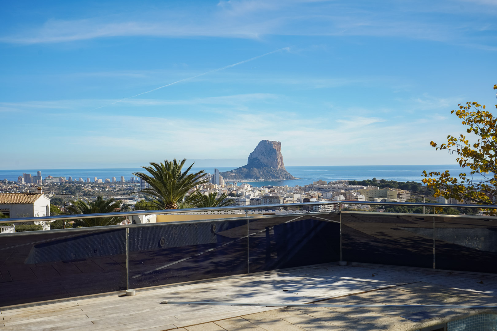 Terrasse avec garde-corps en verre et acier offrant une vue directe sur le Peñón de Ifach, la mer Méditerranée et le centre urbain de Calpe.