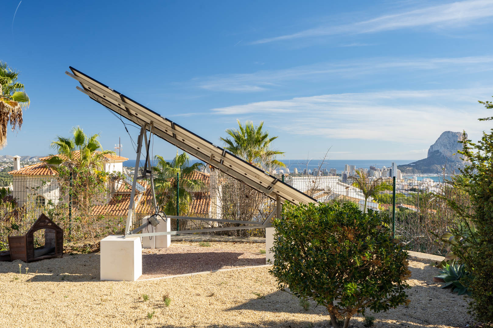 Tour solaire motorisée installée sur un terrain en gravier, offrant une vue panoramique sur la silhouette de Calpe et le rocher d'Ifach.