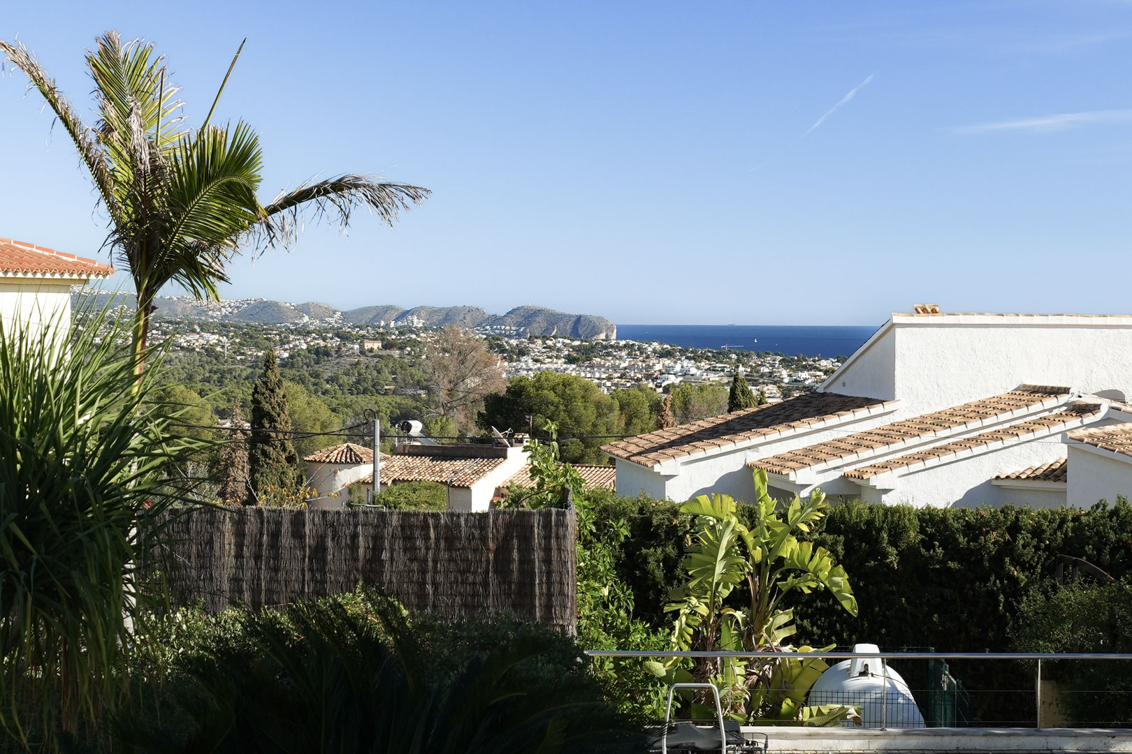 Vues panoramiques sur la mer Méditerranée et le Cap d'Or, entourées d'une végétation luxuriante et de villas traditionnelles aux toits de tuiles.