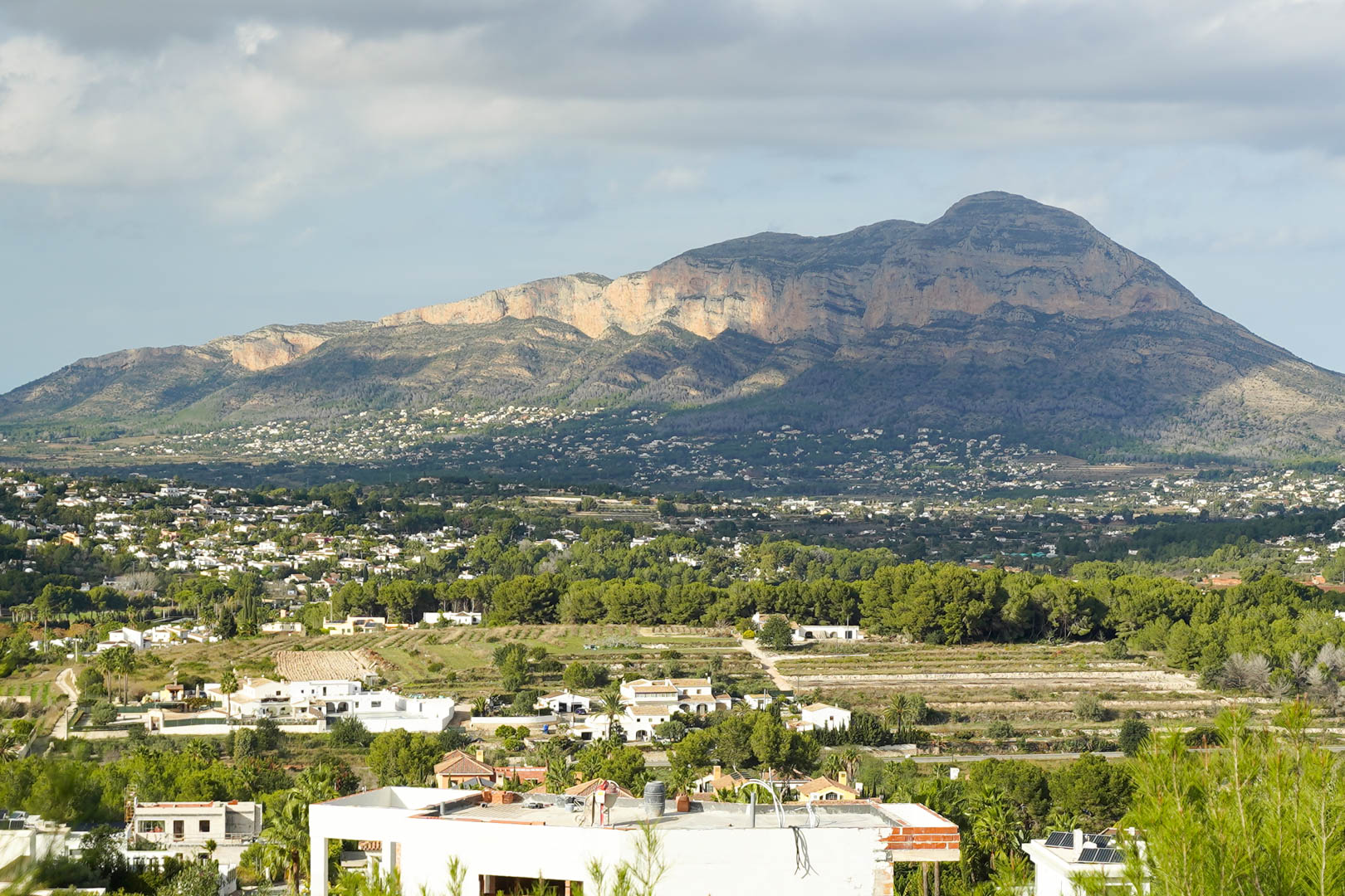 Vue panoramique sur le massif du Montgó depuis le terrain, surplombant les villas blanches et la végétation méditerranéenne environnante sous un ciel dégagé.
