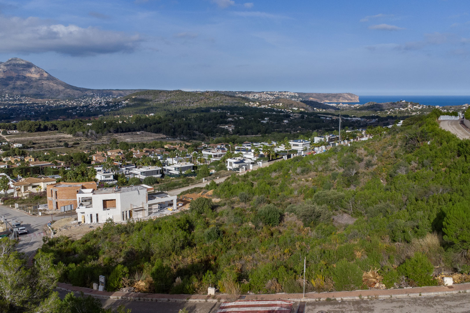 Vue surélevée du terrain à Monte Olímpico, avec le massif du Montgó et la mer Méditerranée bordant le Cabo de San Antonio à l'horizon.
