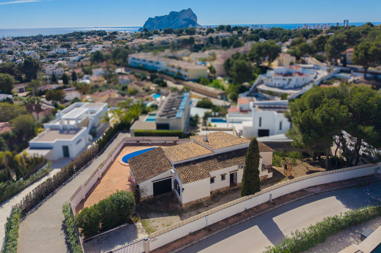Vue aérienne de la villa méditerranéenne avec toiture en tuiles, piscine privée et vue dégagée sur la mer et le célèbre rocher Peñón de Ifach.