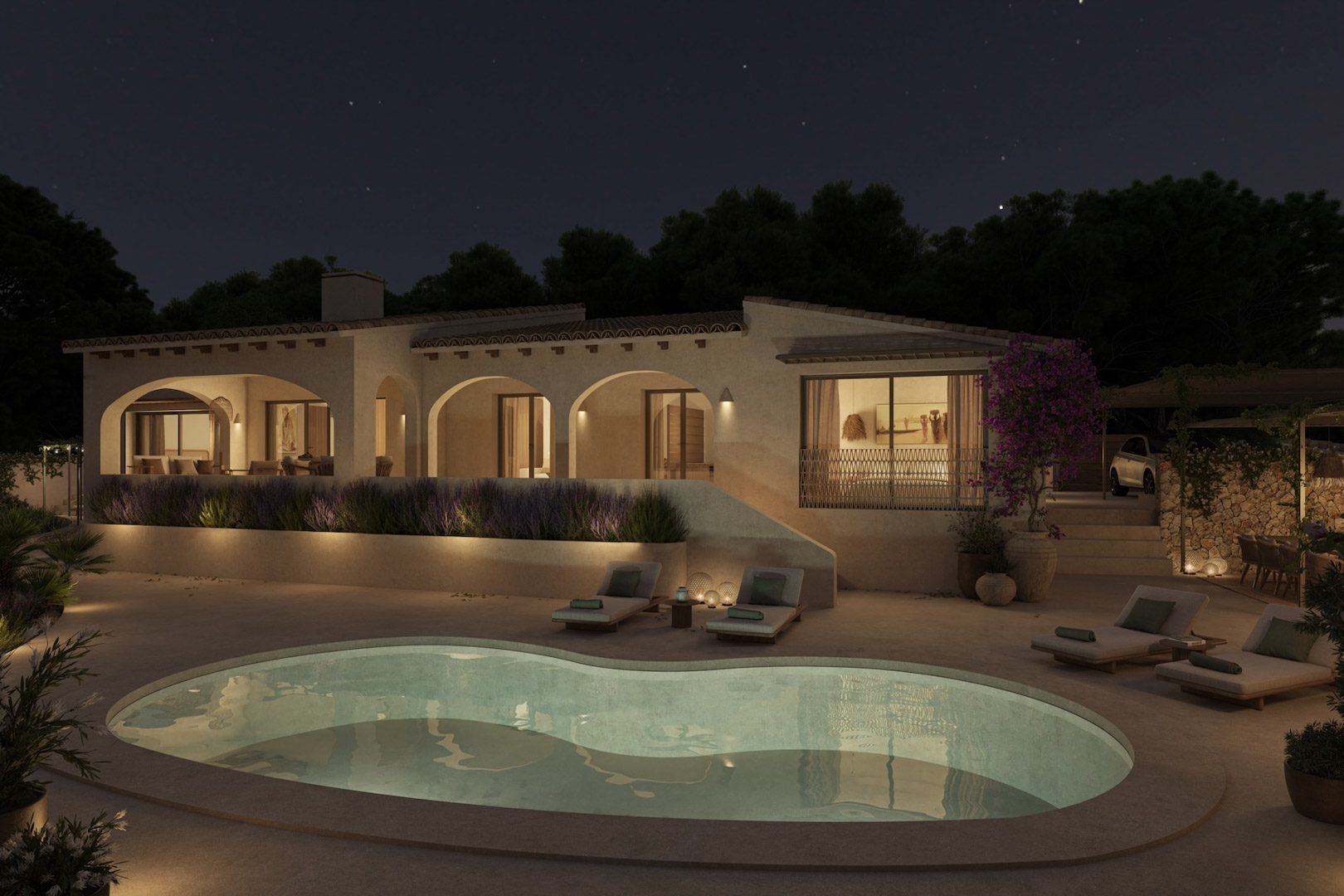 Vue nocturne de la villa avec ses porches à arcades, une piscine de forme organique éclairée et une terrasse entourée de lavande et de bougainvilliers.