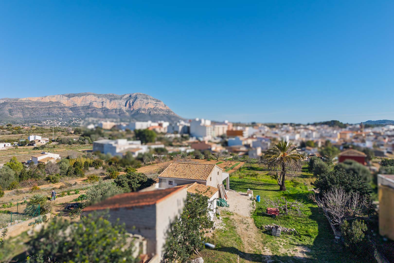Vue panoramique de la propriété avec le massif du Montgó en arrière-plan, illustrant l'étendue du terrain et sa proximité avec le village de Gata de Gorgos.