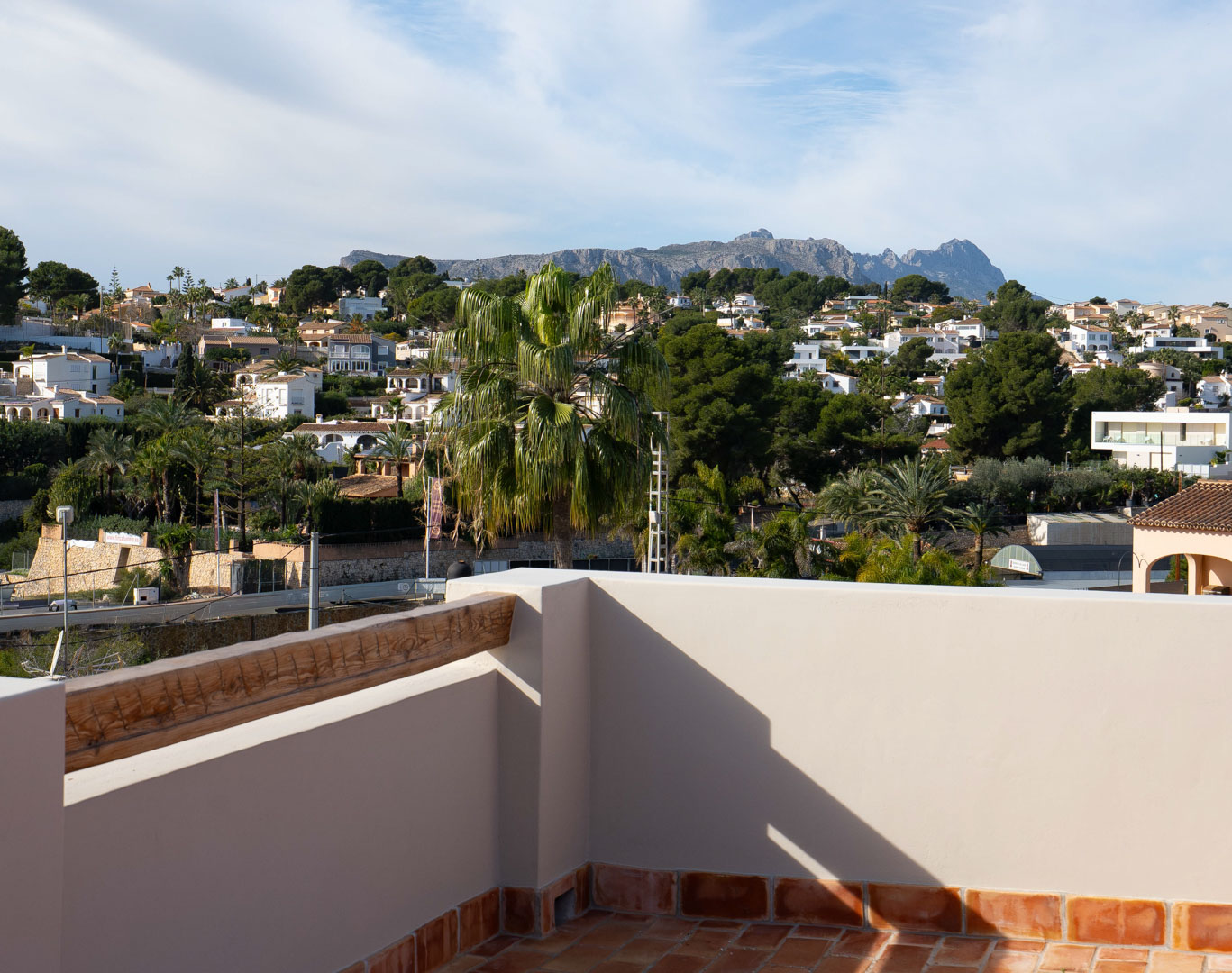 Toit-terrasse avec sol en terre cuite offrant une vue dégagée sur la Sierra de Bernia et le paysage résidentiel de Benissa.
