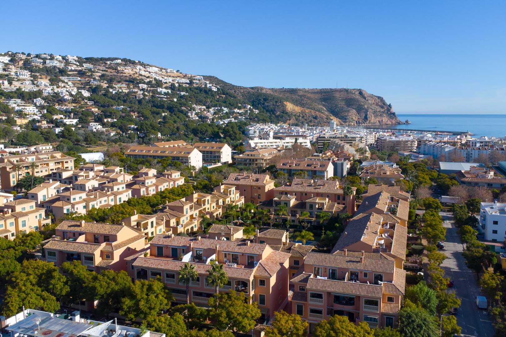 Vue aérienne du complexe Floridamar à Jávea, illustrant l'architecture méditerranéenne, les jardins arborés et la proximité du port et de la mer.