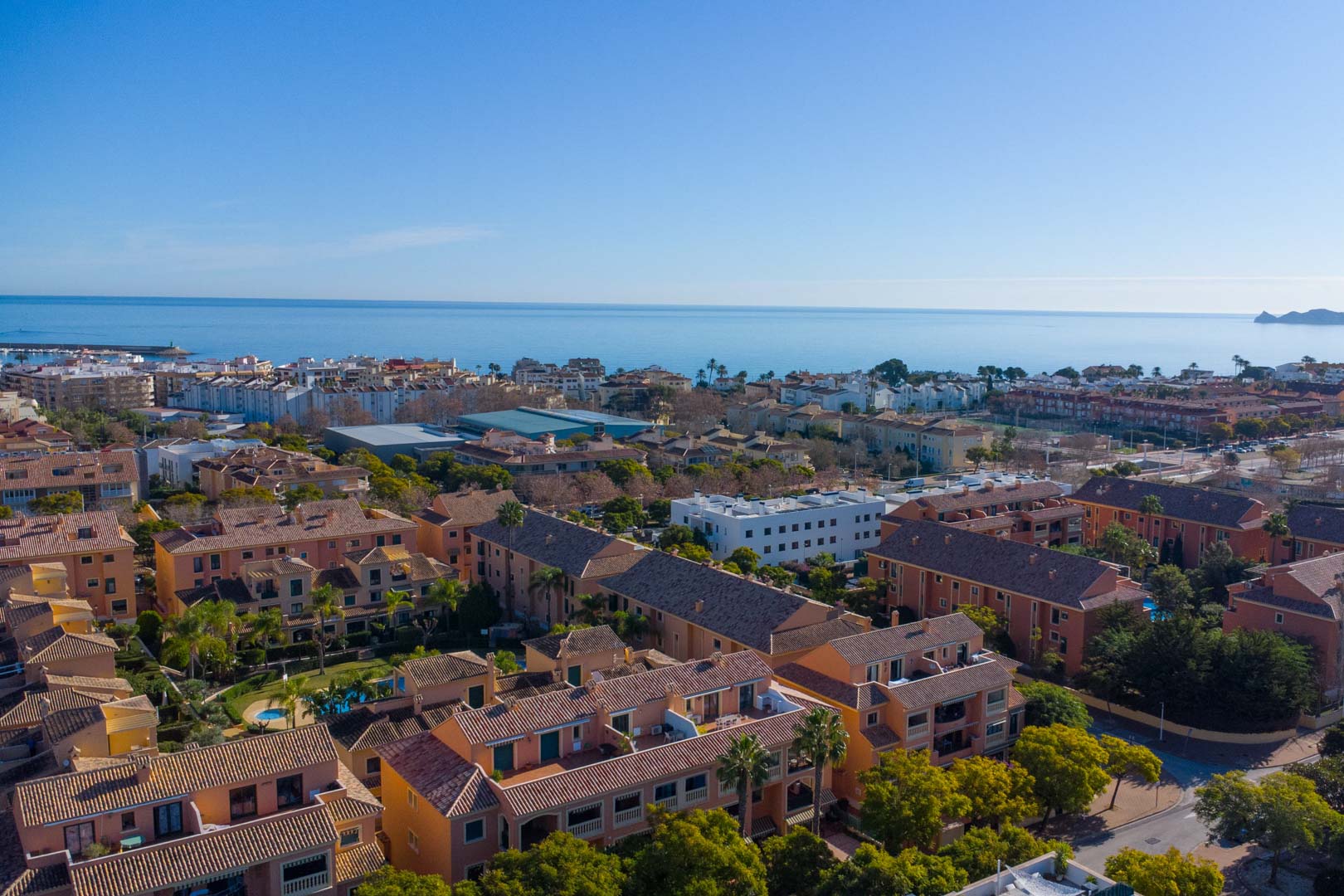 Vue aérienne du complexe Floridamar à Jávea, illustrant l'architecture méditerranéenne, les jardins paysagers et la proximité immédiate de la mer.