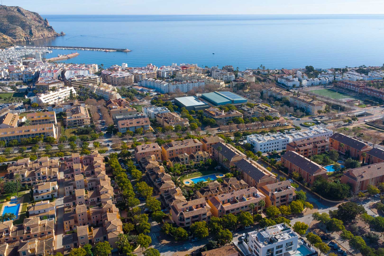 Vue aérienne du complexe Floridamar à Jávea, mettant en valeur la piscine centrale et sa situation privilégiée à proximité du port et de la mer.