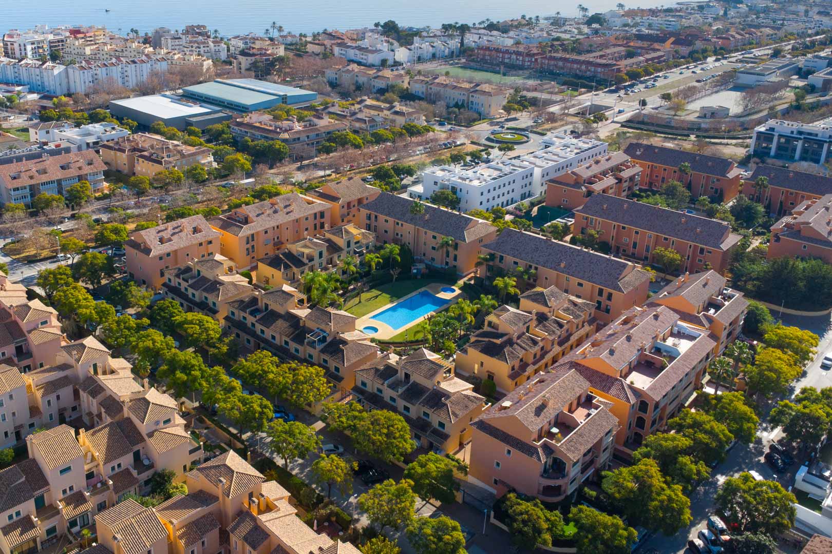 Vue aérienne du complexe Floridamar à Jávea, mettant en valeur la piscine centrale, les jardins paysagers et la proximité de la mer Méditerranée.