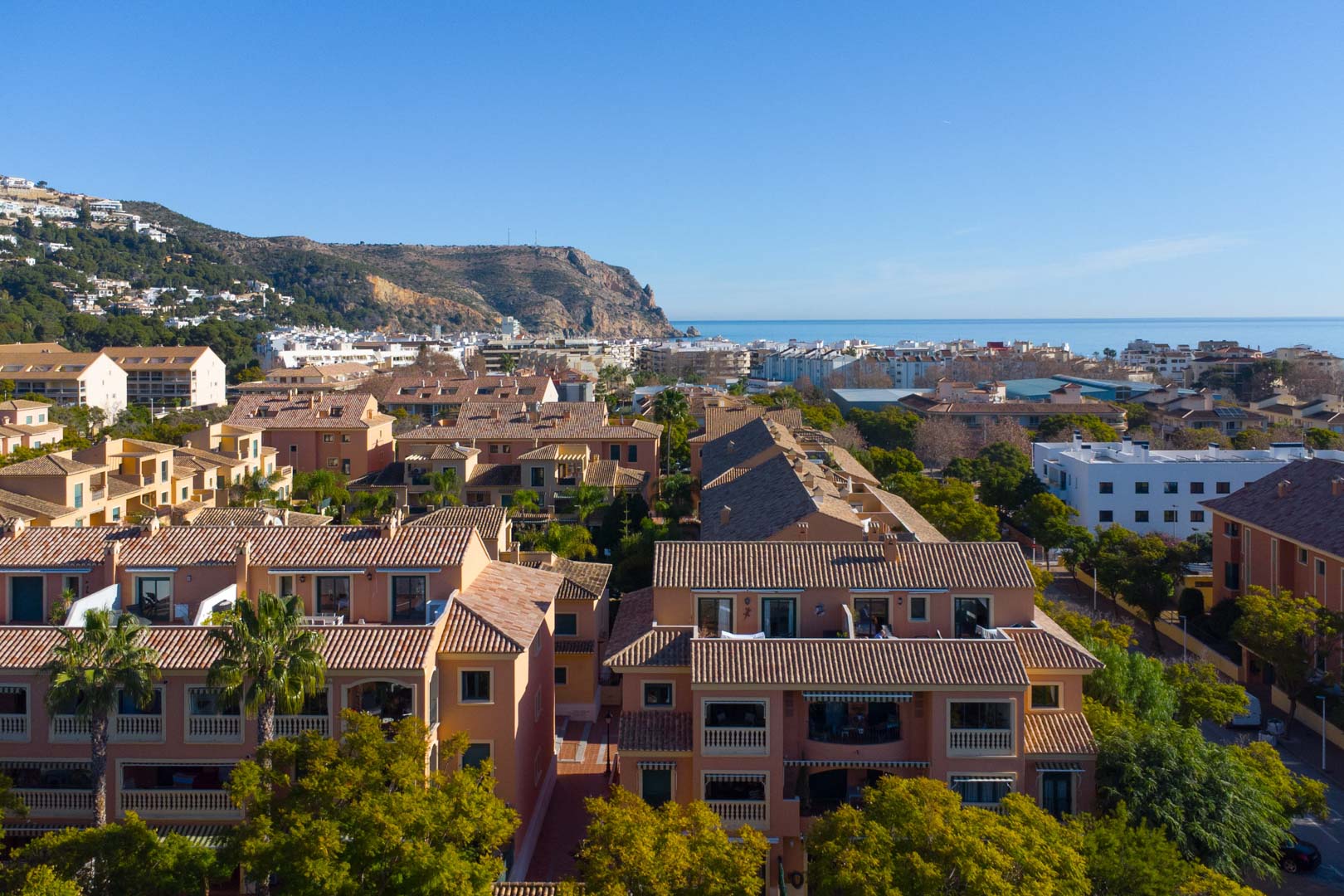 Vue aérienne panoramique du complexe Floridamar avec ses toits en terre cuite, offrant une perspective sur la mer Méditerranée et le mont Cabo de San Antonio.
