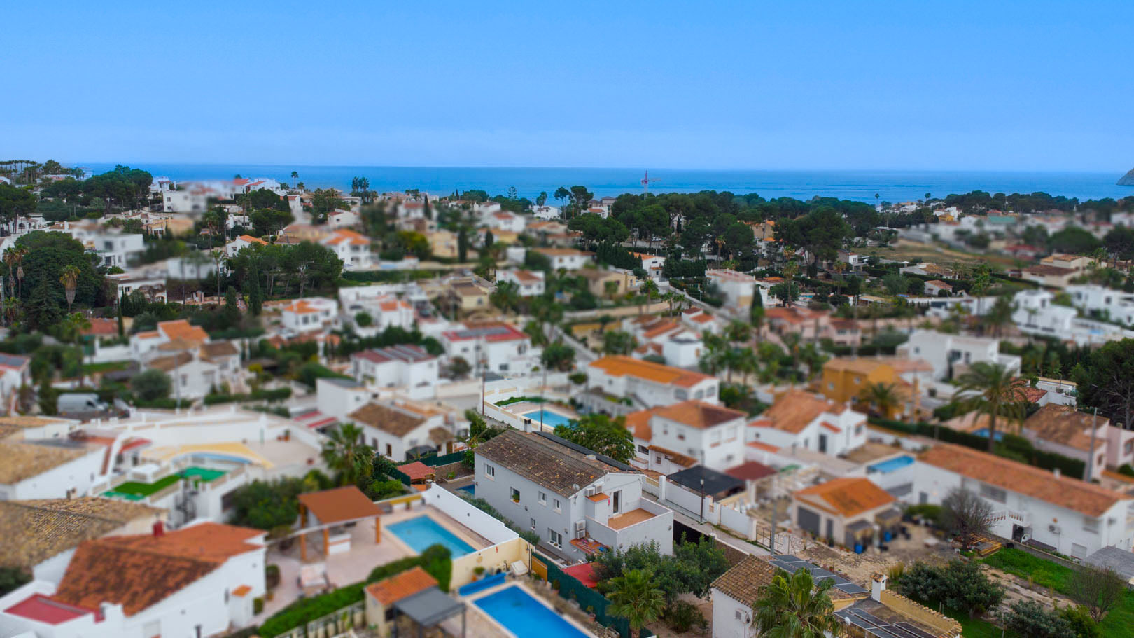 Vue aérienne de l'urbanisation Carrio à Calpe, illustrant la proximité de la mer Méditerranée et l'agencement des villas avec piscines privées.