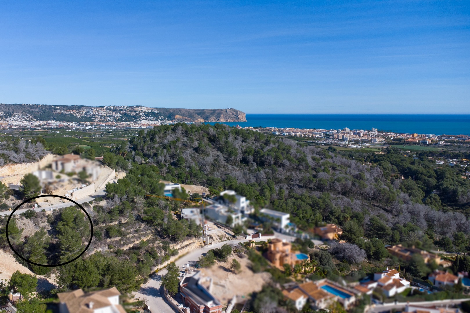Vue aérienne de la parcelle surélevée à Tosalet 5, entourée de pins, offrant une vue panoramique sur la mer Méditerranée et le littoral de Jávea.