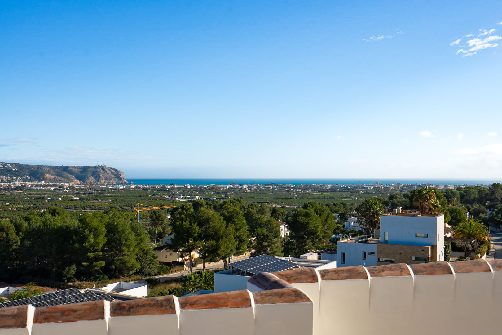 Vues panoramiques depuis la terrasse supérieure sur la mer Méditerranée et la côte, avec la silhouette du cap et la végétation locale environnante.