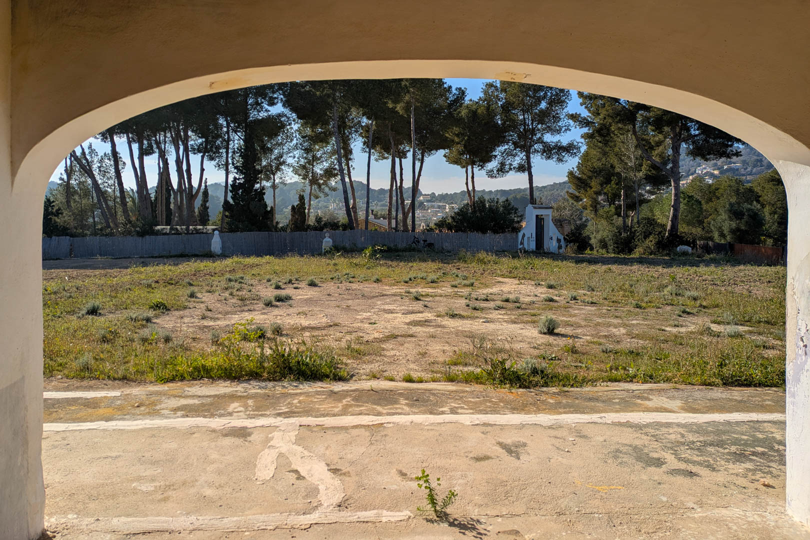 Vue depuis une naya voûtée sur le vaste terrain plat, entouré de pins matures et d'un environnement naturel paisible à Jávea.