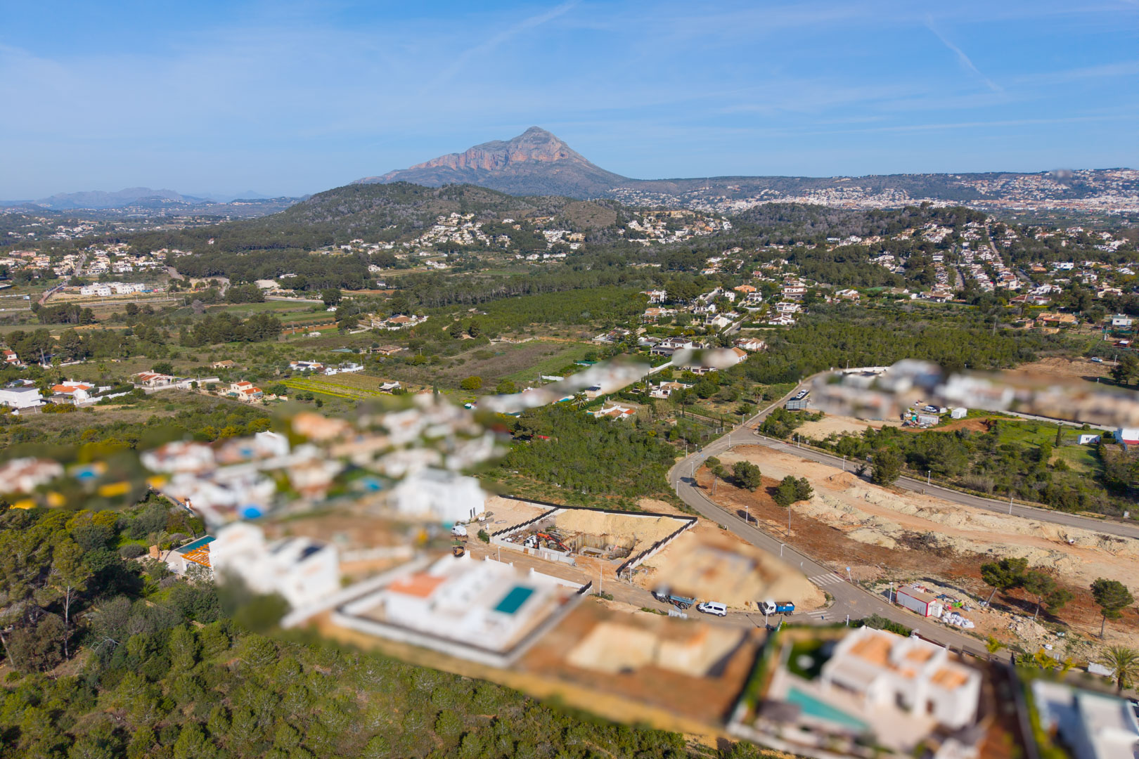 Vue aérienne du quartier résidentiel Valsol à Jávea, mettant en valeur l'environnement verdoyant et la montagne Montgó en arrière-plan.