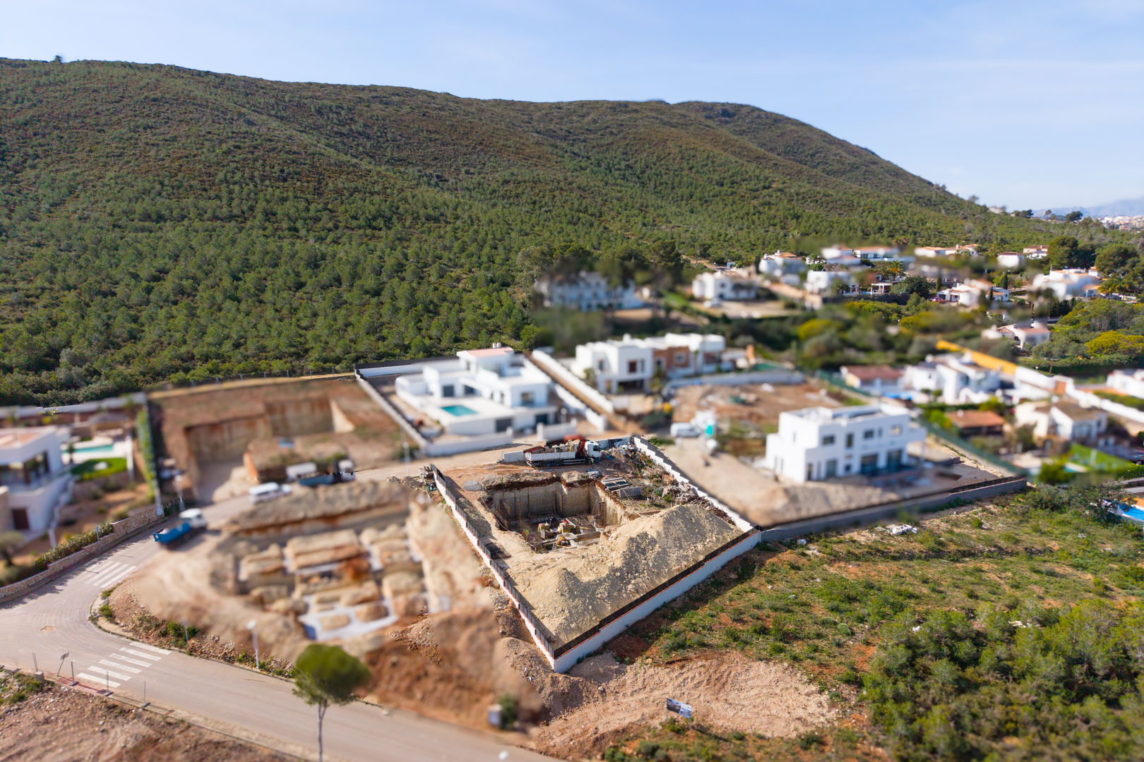 Vue aérienne du terrain en construction à Valsol, illustrant la phase d'excavation et de fondation au cœur d'un quartier résidentiel moderne et verdoyant.