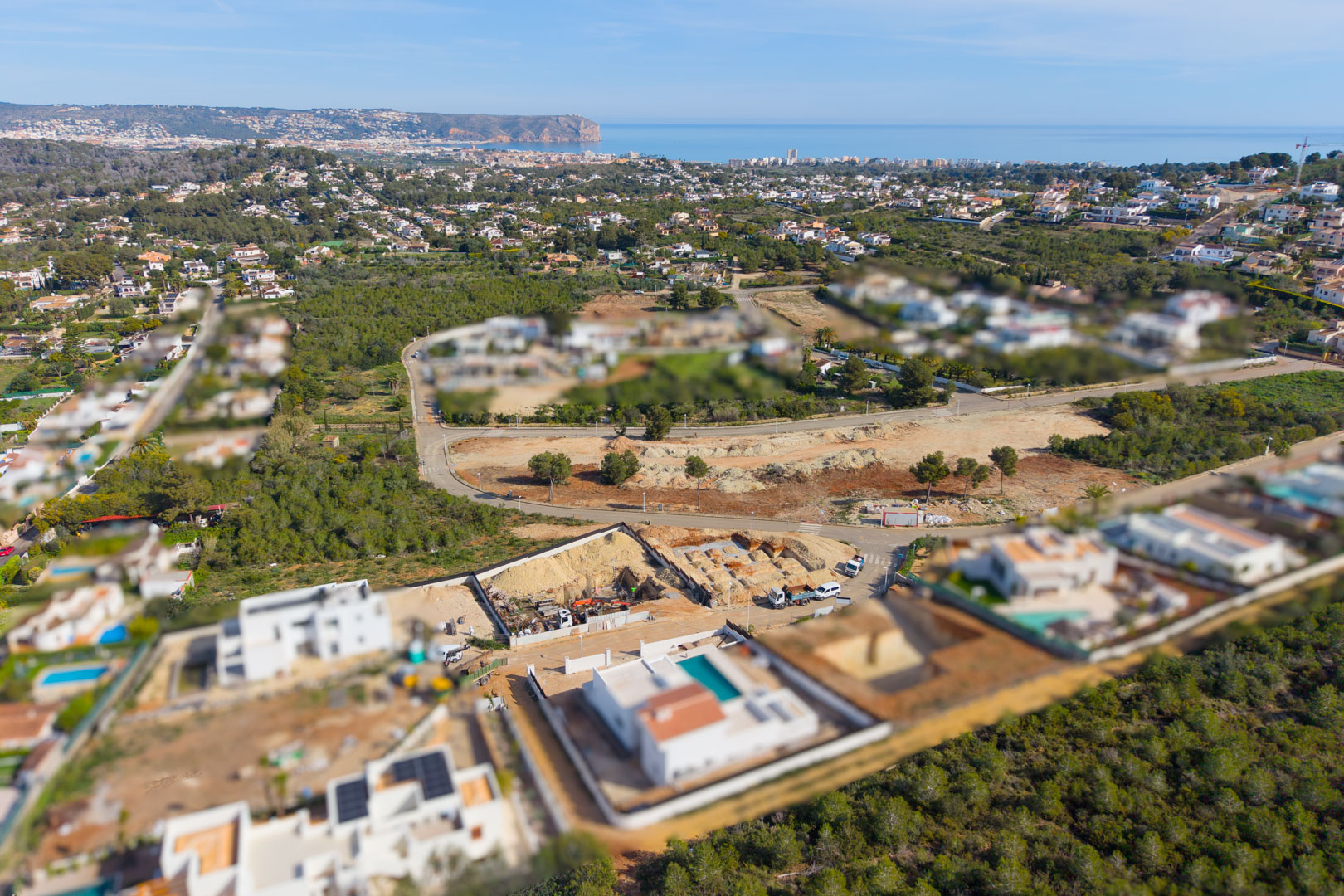Vue aérienne du terrain en construction à Valsol, Jávea, montrant les travaux de fondation et le panorama sur la mer Méditerranée et la côte.
