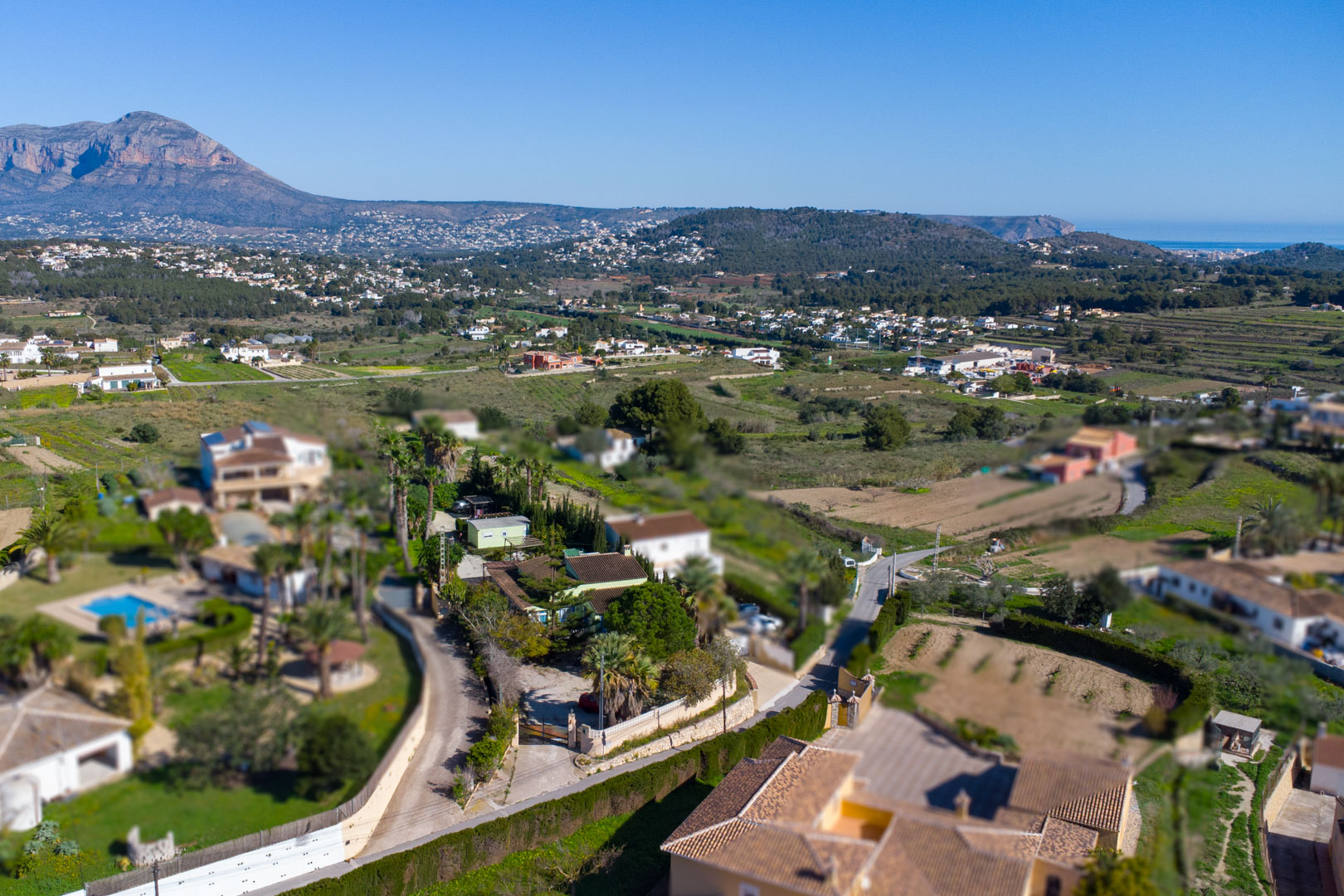 Vue aérienne de la finca traditionnelle et de son terrain rustique, avec une vue panoramique sur le Montgó et le littoral méditerranéen.