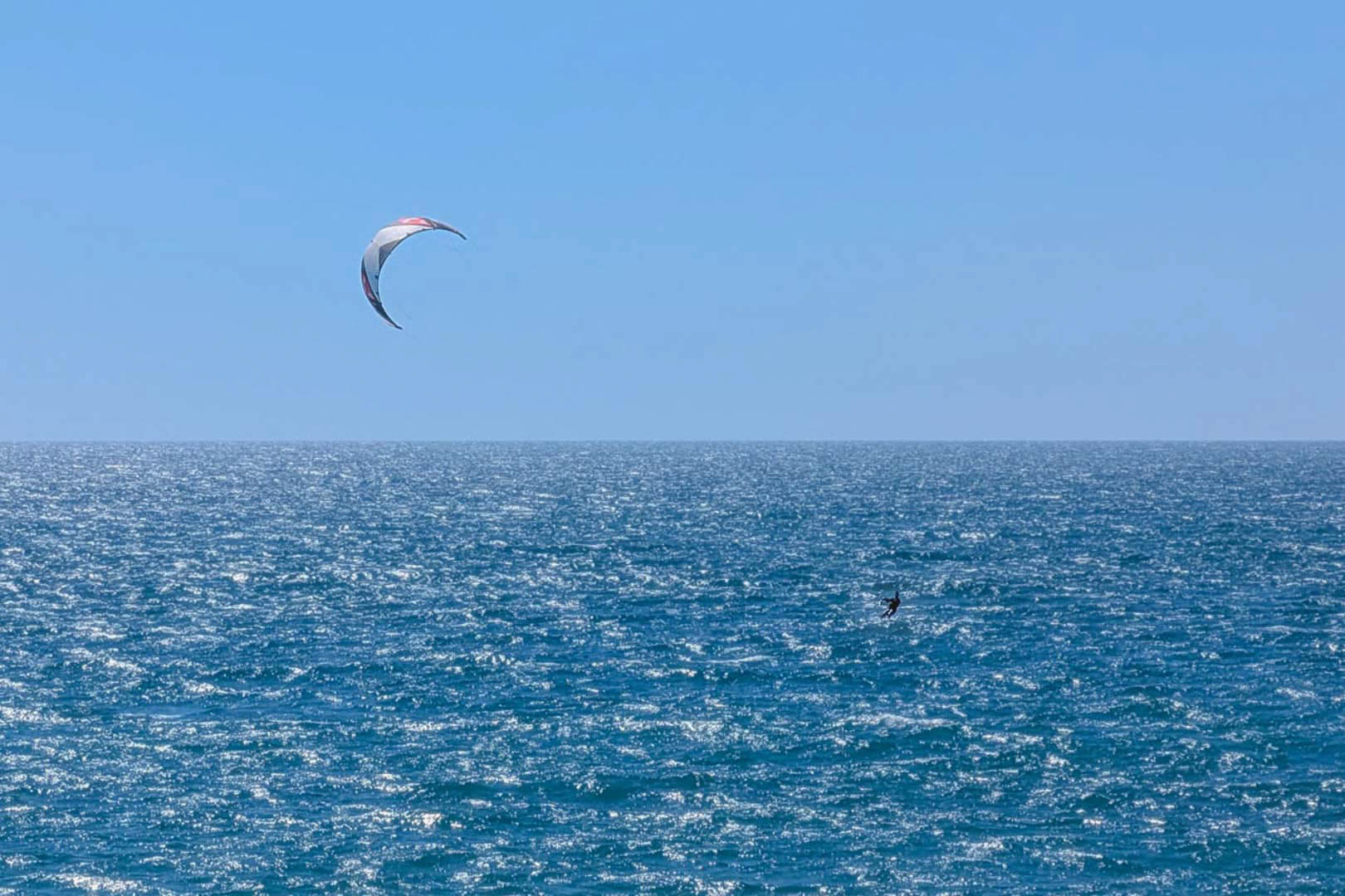 Vue panoramique sur la mer Méditerranée à Calpe, illustrant la pratique du kitesurf dans un cadre maritime paisible et ensoleillé.