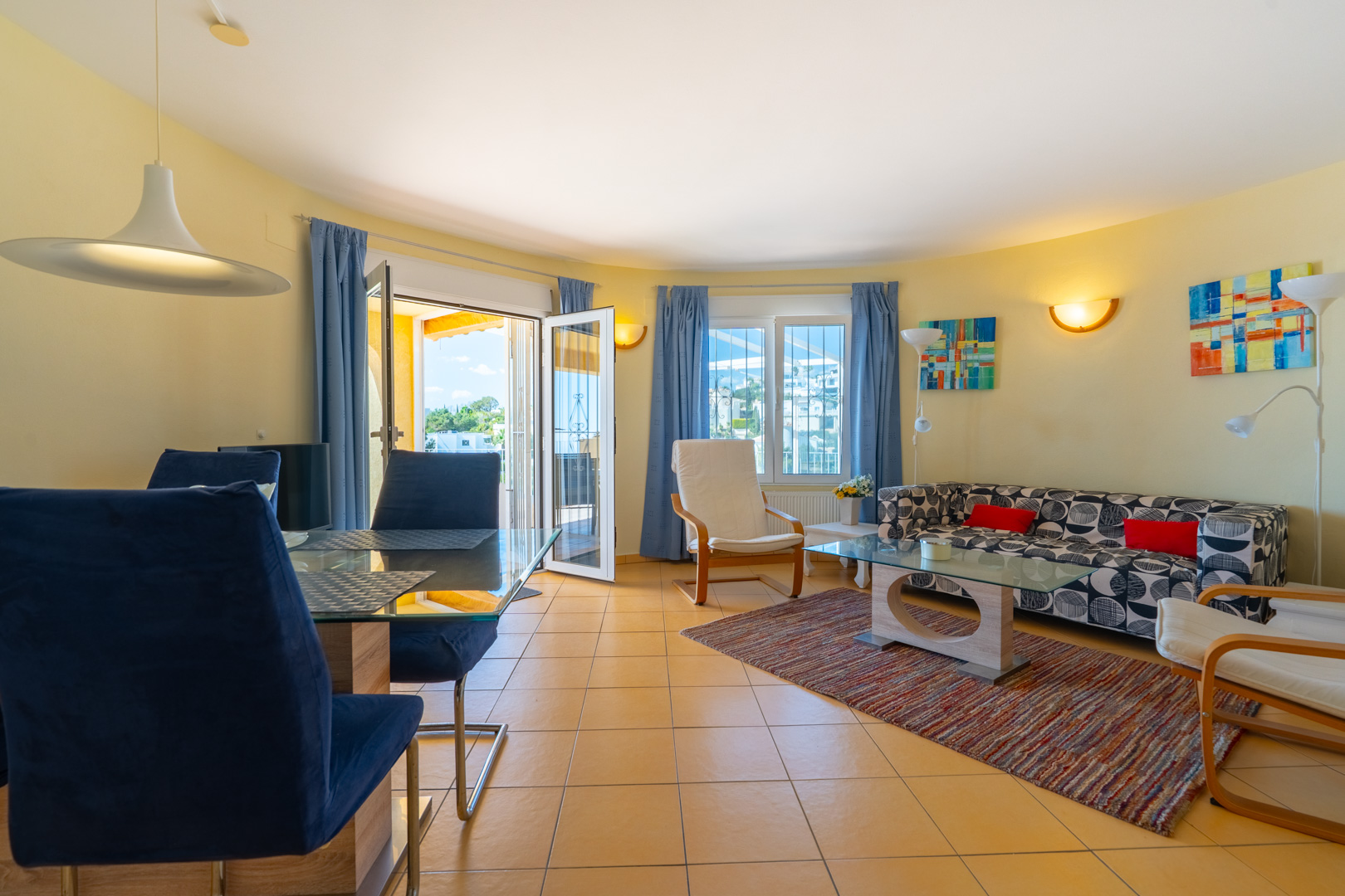 Salon-salle à manger lumineux avec carrelage au sol, mobilier contemporain et accès direct à la terrasse, baigné de lumière naturelle par les ouvertures.