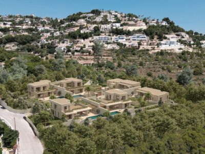 Vue aérienne d'un complexe résidentiel moderne avec villas aux façades claires et piscines privées, intégré dans un flanc de colline verdoyant.