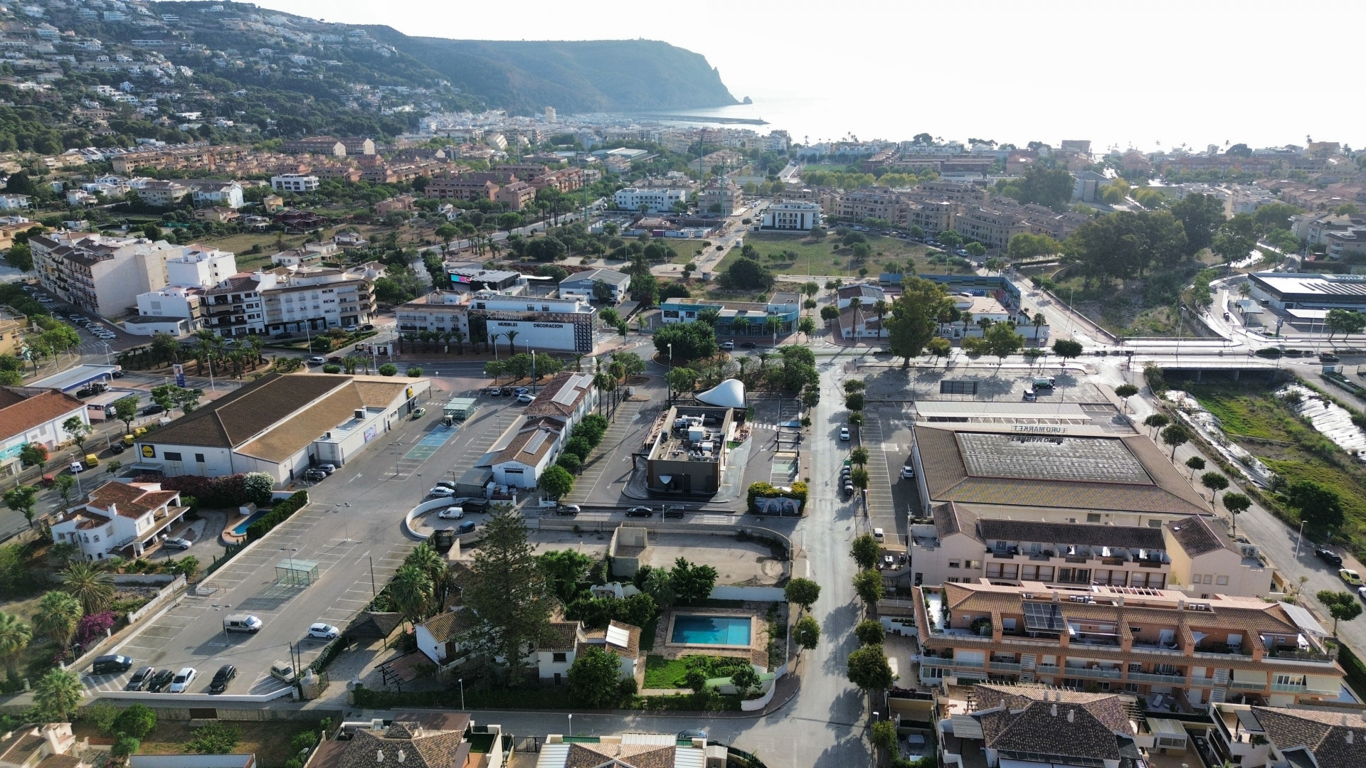 Vue aérienne de la propriété proche des commodités, avec piscine privée et grand parking.